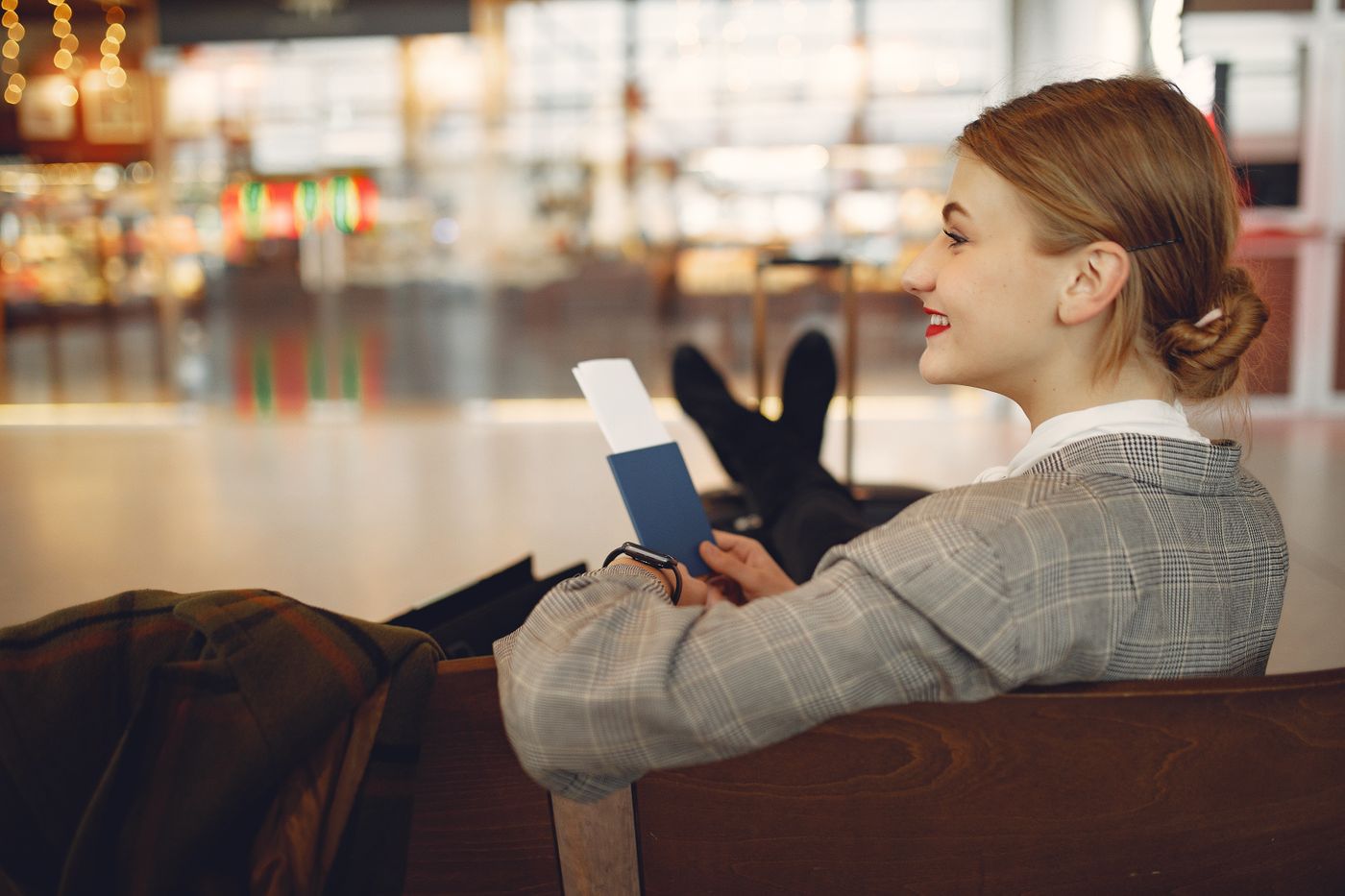 Smiling student with passport and boarding pass at the airport